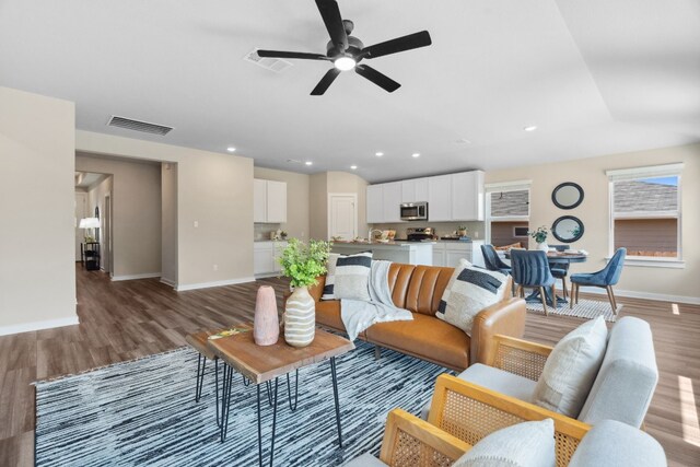 living room featuring ceiling fan and wood-type flooring