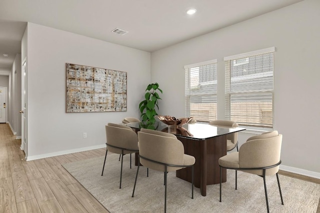 dining space featuring light wood finished floors, recessed lighting, visible vents, and baseboards