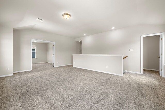 empty room featuring light carpet and vaulted ceiling