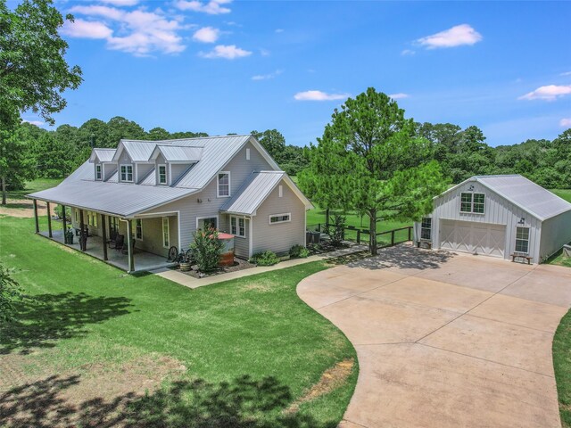 view of front facade with a front yard, a garage, and an outbuilding