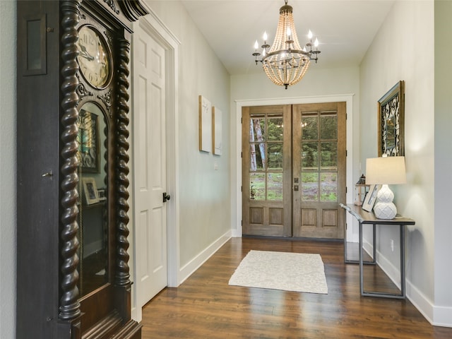 foyer entrance with french doors, a notable chandelier, and dark wood-type flooring