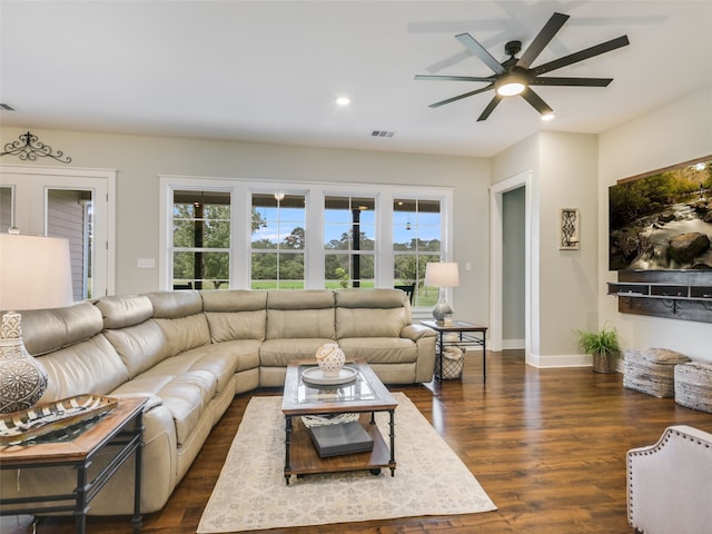 living room with dark hardwood / wood-style flooring, ceiling fan, and plenty of natural light