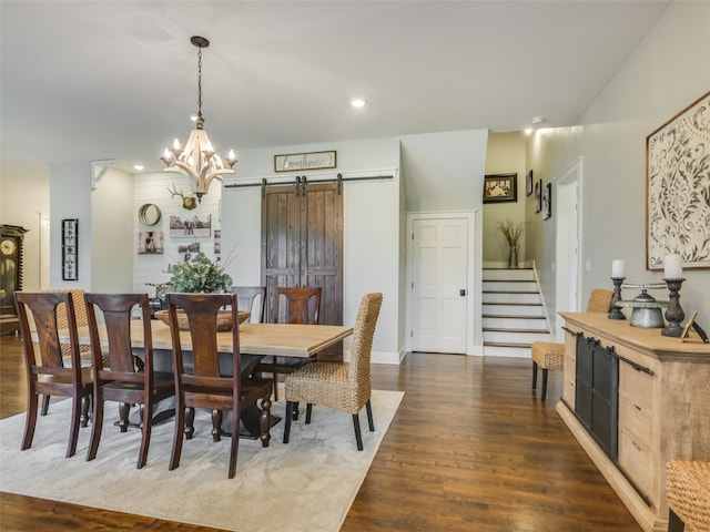 dining room featuring a notable chandelier, a barn door, and dark hardwood / wood-style floors