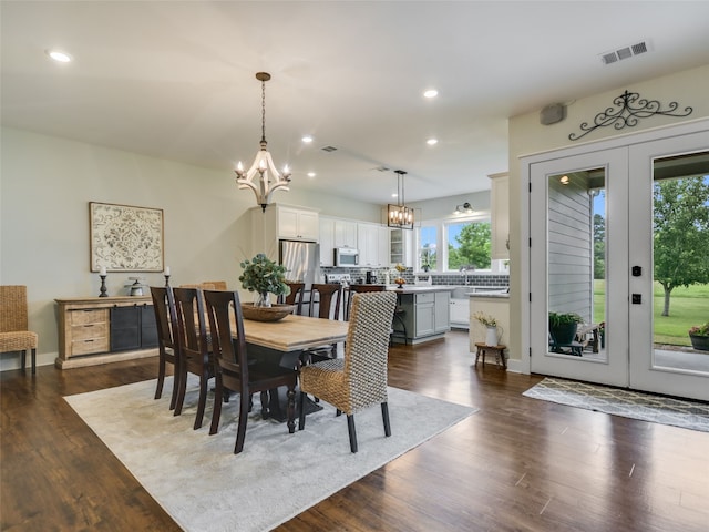 dining area with french doors, dark hardwood / wood-style flooring, and a chandelier