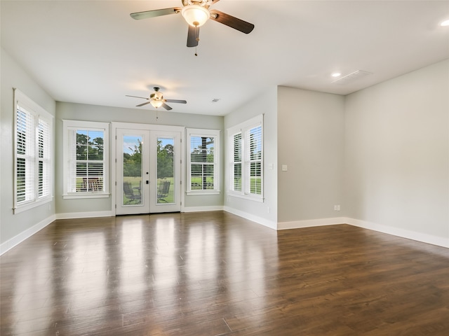 unfurnished living room with ceiling fan, french doors, a wealth of natural light, and dark hardwood / wood-style floors