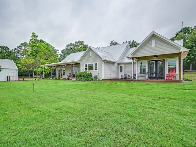 back of house with ceiling fan and a lawn