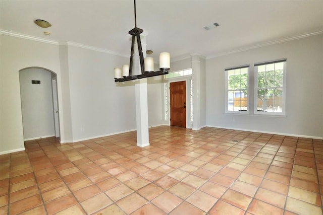 tiled spare room featuring ornamental molding and a chandelier