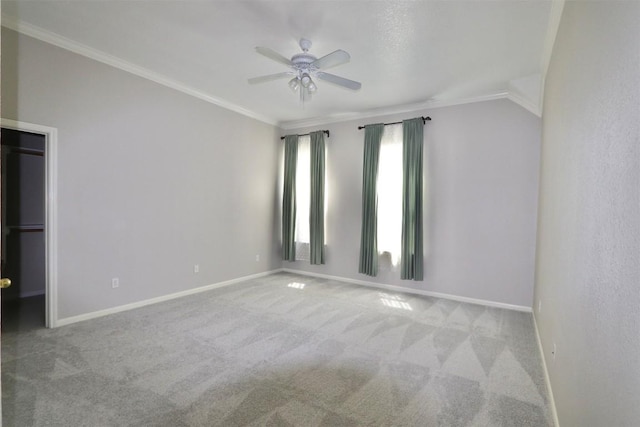 carpeted empty room featuring ceiling fan, lofted ceiling, and ornamental molding