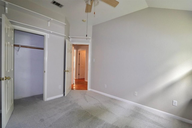 unfurnished bedroom featuring ceiling fan, a closet, light carpet, and lofted ceiling