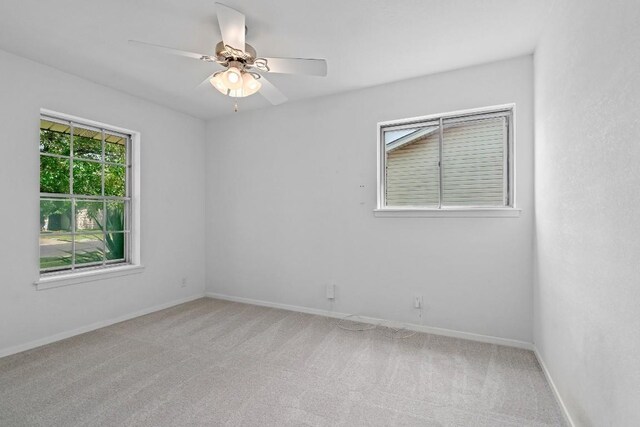 carpeted spare room with ceiling fan