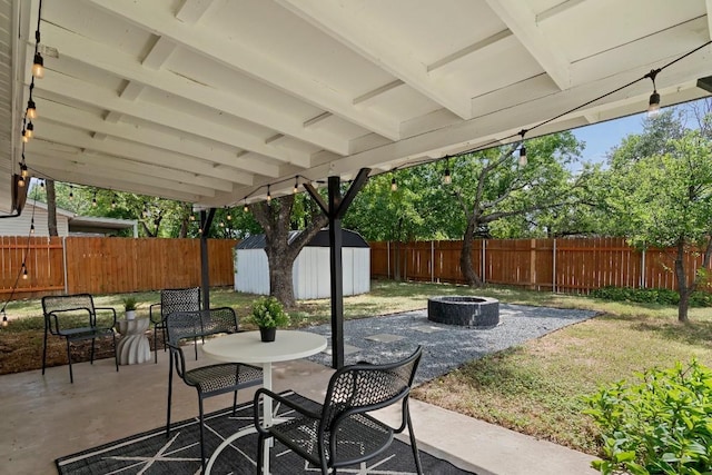 view of patio / terrace featuring a storage shed and an outdoor fire pit