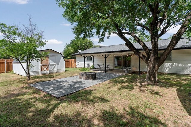 rear view of house featuring a storage unit, a patio area, and a lawn