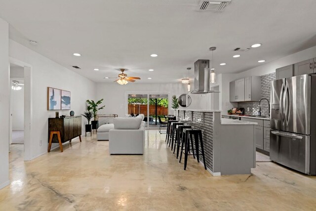 kitchen featuring gray cabinets, stainless steel fridge, island exhaust hood, and ceiling fan