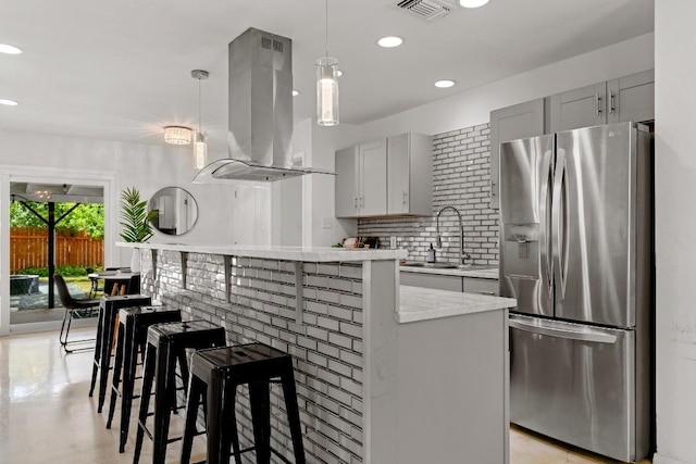 kitchen featuring sink, gray cabinetry, hanging light fixtures, stainless steel refrigerator with ice dispenser, and island exhaust hood