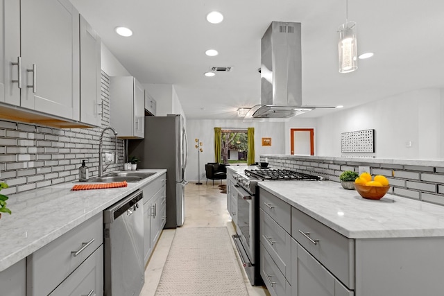 kitchen with appliances with stainless steel finishes, decorative backsplash, decorative light fixtures, island range hood, and gray cabinetry