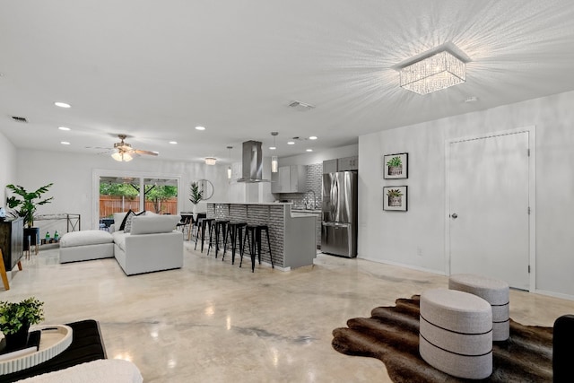 living room featuring ceiling fan with notable chandelier