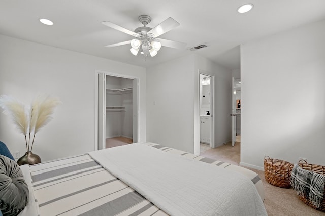 carpeted bedroom with a closet, ceiling fan, and a walk in closet