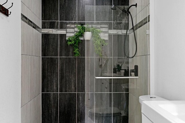 bathroom with vanity and a tile shower