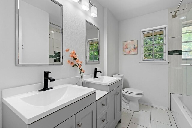 full bathroom featuring vanity, tile patterned flooring, tiled shower / bath combo, and toilet