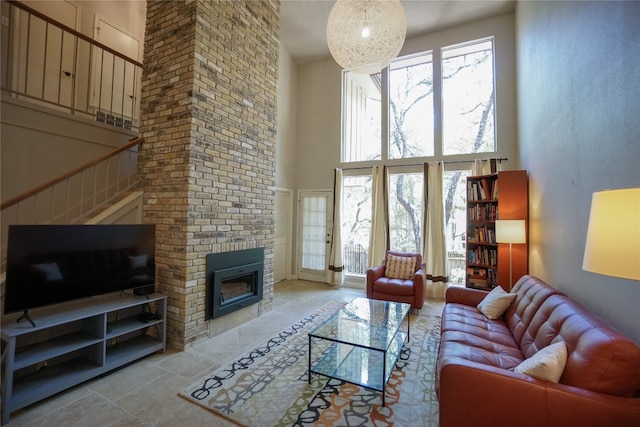 tiled living room featuring a fireplace and a high ceiling