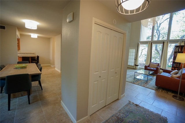 hallway featuring tile patterned flooring and an inviting chandelier