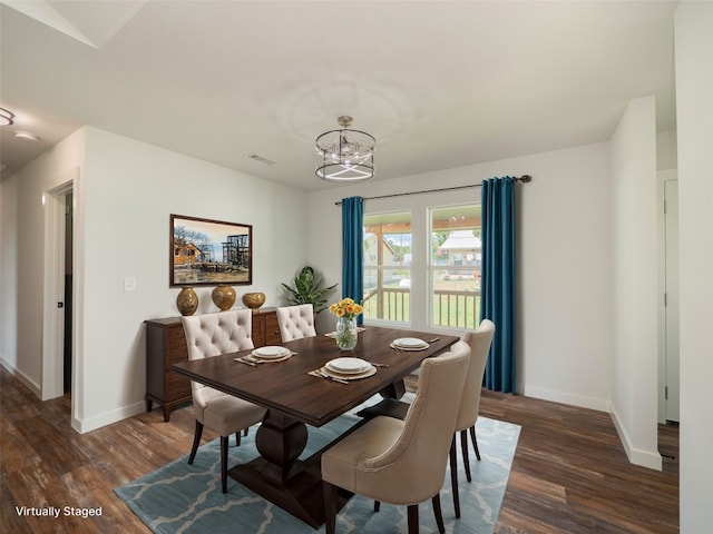 dining space with dark hardwood / wood-style floors and a chandelier