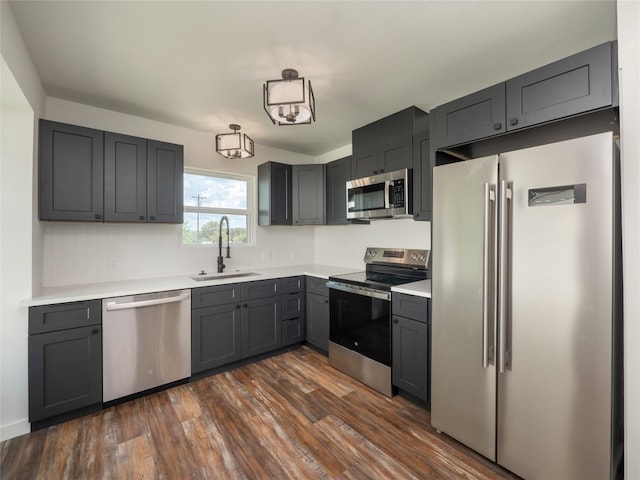 kitchen featuring gray cabinets, a chandelier, dark hardwood / wood-style floors, sink, and stainless steel appliances