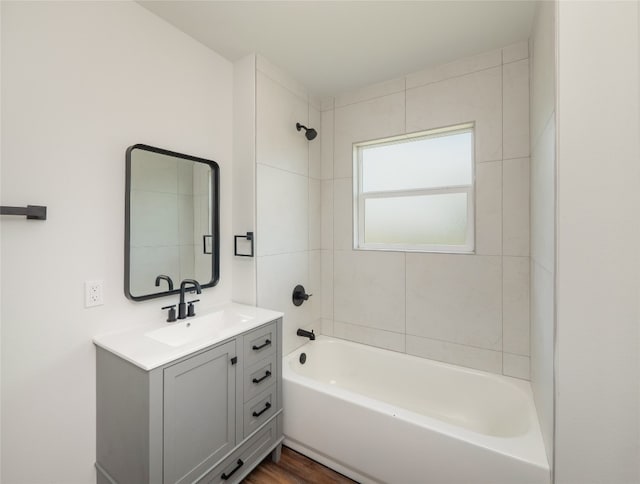 bathroom featuring vanity, tiled shower / bath combo, and hardwood / wood-style floors