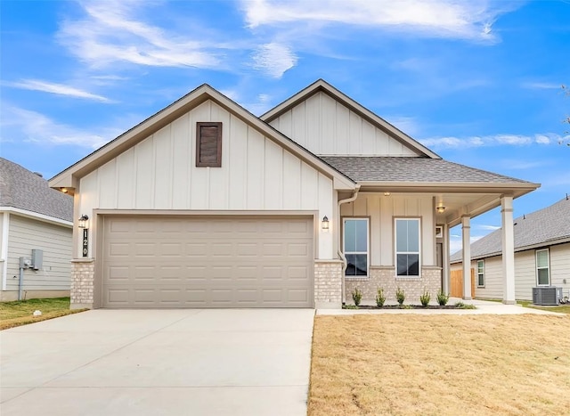 view of front facade featuring a garage, a front lawn, and central air condition unit