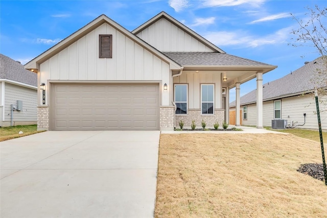 view of front of property with a garage, central AC, and a front yard