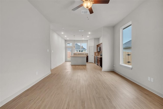 unfurnished living room with light hardwood / wood-style flooring and ceiling fan