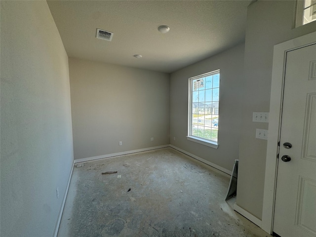 unfurnished room featuring a textured ceiling