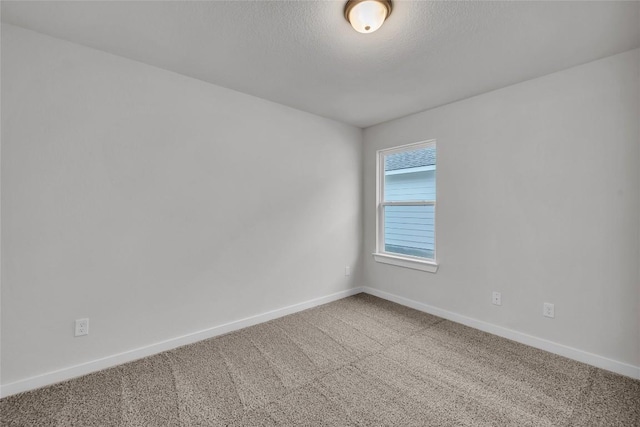 empty room featuring carpet and a textured ceiling