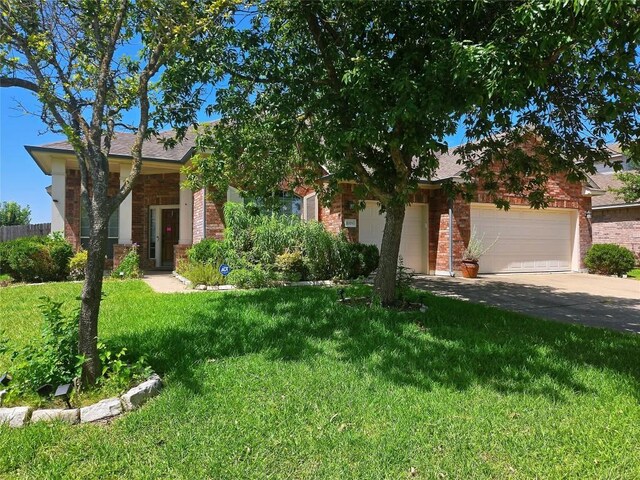 view of property hidden behind natural elements with a garage and a front yard