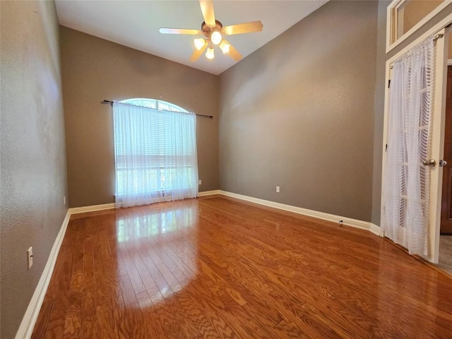 spare room featuring ceiling fan, vaulted ceiling, and wood-type flooring