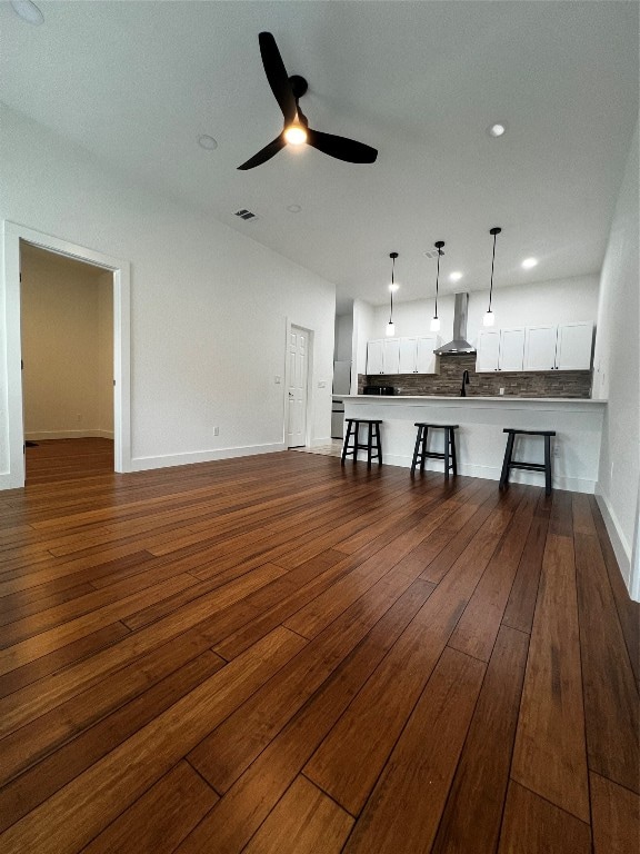 unfurnished living room with hardwood / wood-style flooring and ceiling fan