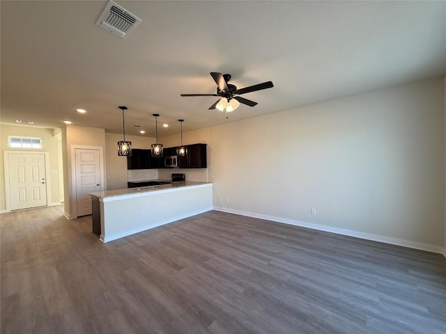 kitchen featuring ceiling fan, dark hardwood / wood-style floors, kitchen peninsula, and stove