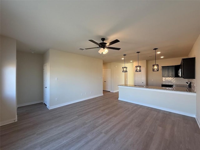 unfurnished living room featuring dark hardwood / wood-style flooring and ceiling fan