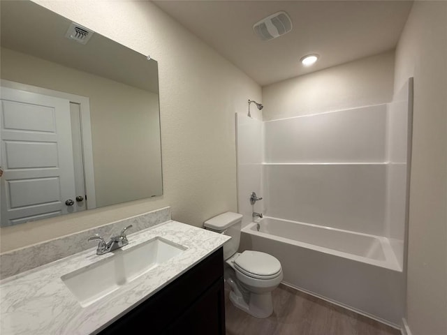 full bathroom with vanity, hardwood / wood-style floors, toilet, and washtub / shower combination