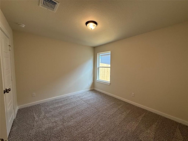 carpeted spare room with a textured ceiling