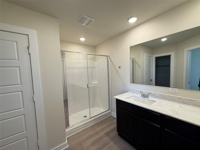 bathroom featuring vanity, hardwood / wood-style floors, and walk in shower