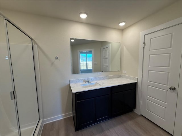 bathroom featuring vanity, hardwood / wood-style flooring, and a shower with shower door