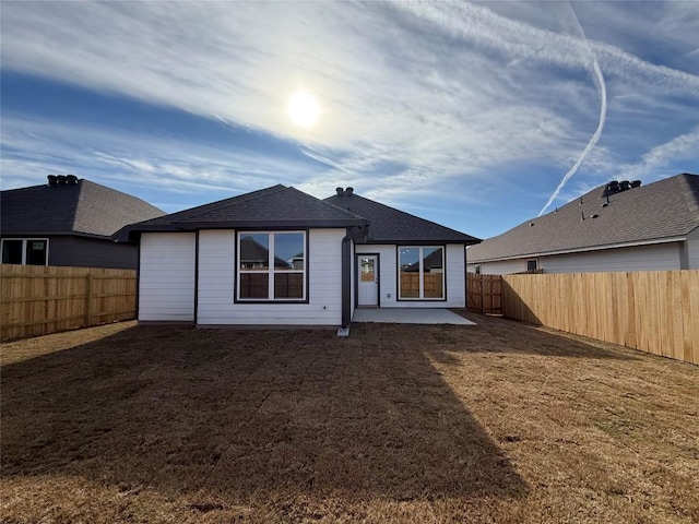 back of property with a yard and a patio