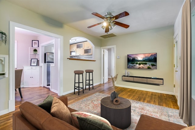 living room featuring wood-type flooring and ceiling fan