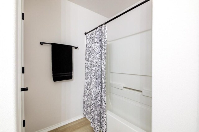 bathroom featuring shower / tub combo with curtain and hardwood / wood-style flooring