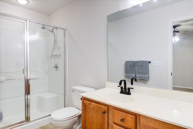 bathroom featuring vanity, a shower with shower door, and toilet