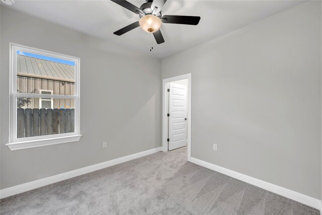 carpeted spare room with ceiling fan