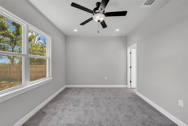 spare room with ceiling fan and light carpet