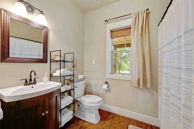 bathroom featuring toilet, vanity, and hardwood / wood-style floors