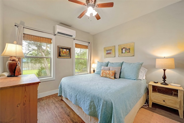 bedroom with ceiling fan, hardwood / wood-style floors, and a wall mounted air conditioner